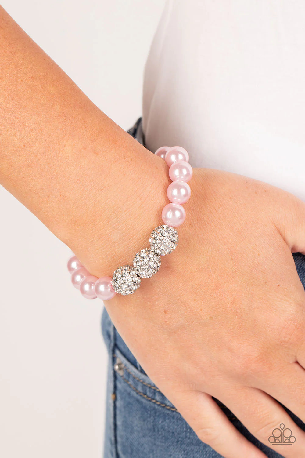 Paparazzi Accessories Breathtaking Ball - Pink A trio of silver beads encrusted in rhinestones is centered along a strand of classic baby pink pearls. The beads are threaded along a stretchy band, wrapping around the wrist in a refined finish. Sold as one