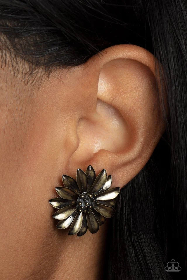 Paparazzi Accessories Daisy Dilemma - Brass Layers of burnished brass petals flare out from a brass studded center, blooming into a rustic floral fantasy. Earring attaches to a standard post fitting. Sold as one pair of post earrings. Jewelry