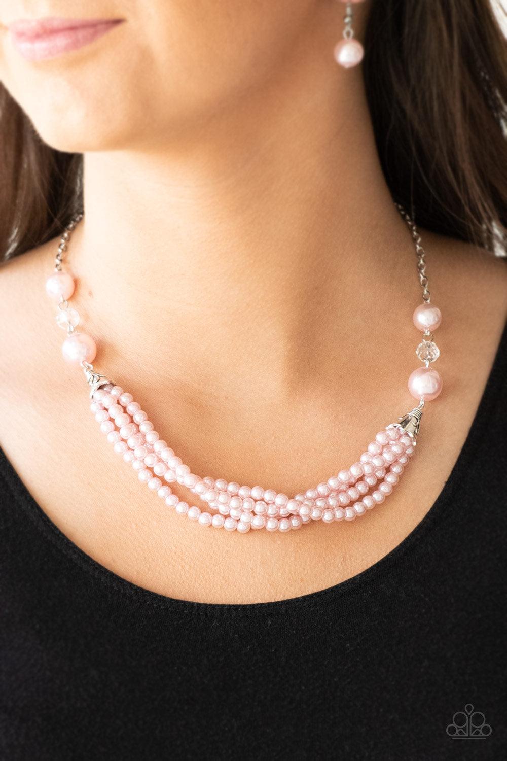 Paparazzi Accessories One-WOMAN Show - Pink Oversized pink pearls and crystal-like beads give way to layers of beaded pearl strands below the collar for a timeless look. Features an adjustable clasp closure. Sold as one individual necklace. Includes one p