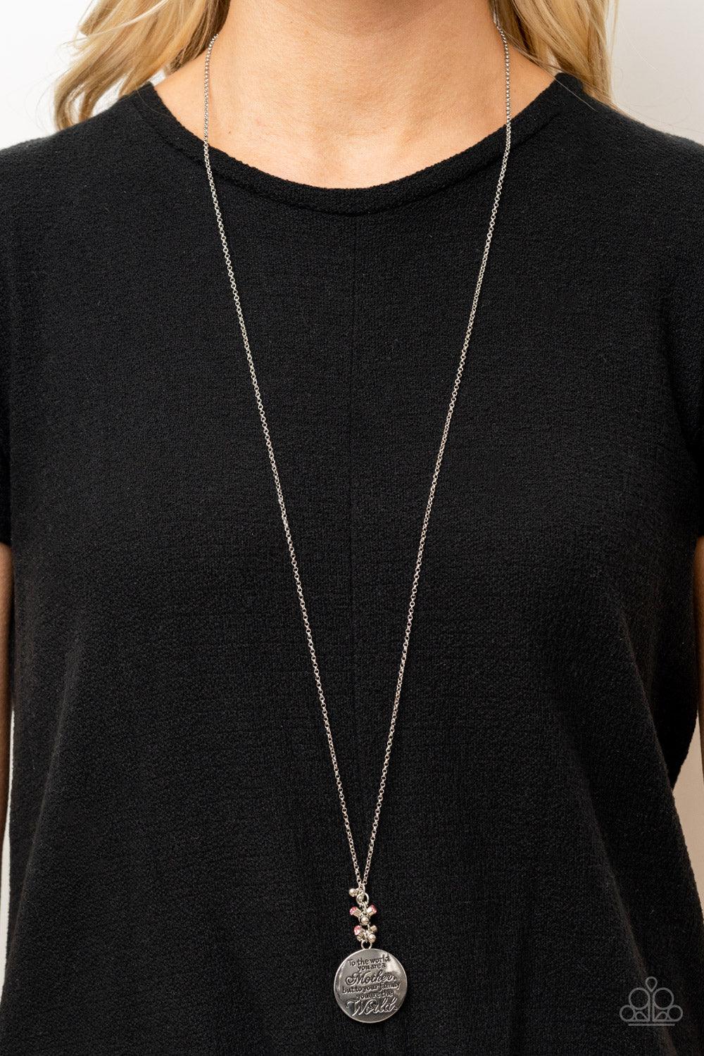 Paparazzi Accessories Maternal Blessings - Pink A silver disc inscribed with the phrase, "To the world you are a Mother, but to your family you are the World," creates a sweet reminder as it falls from a lengthened silver chain. A sprinkle of dainty light
