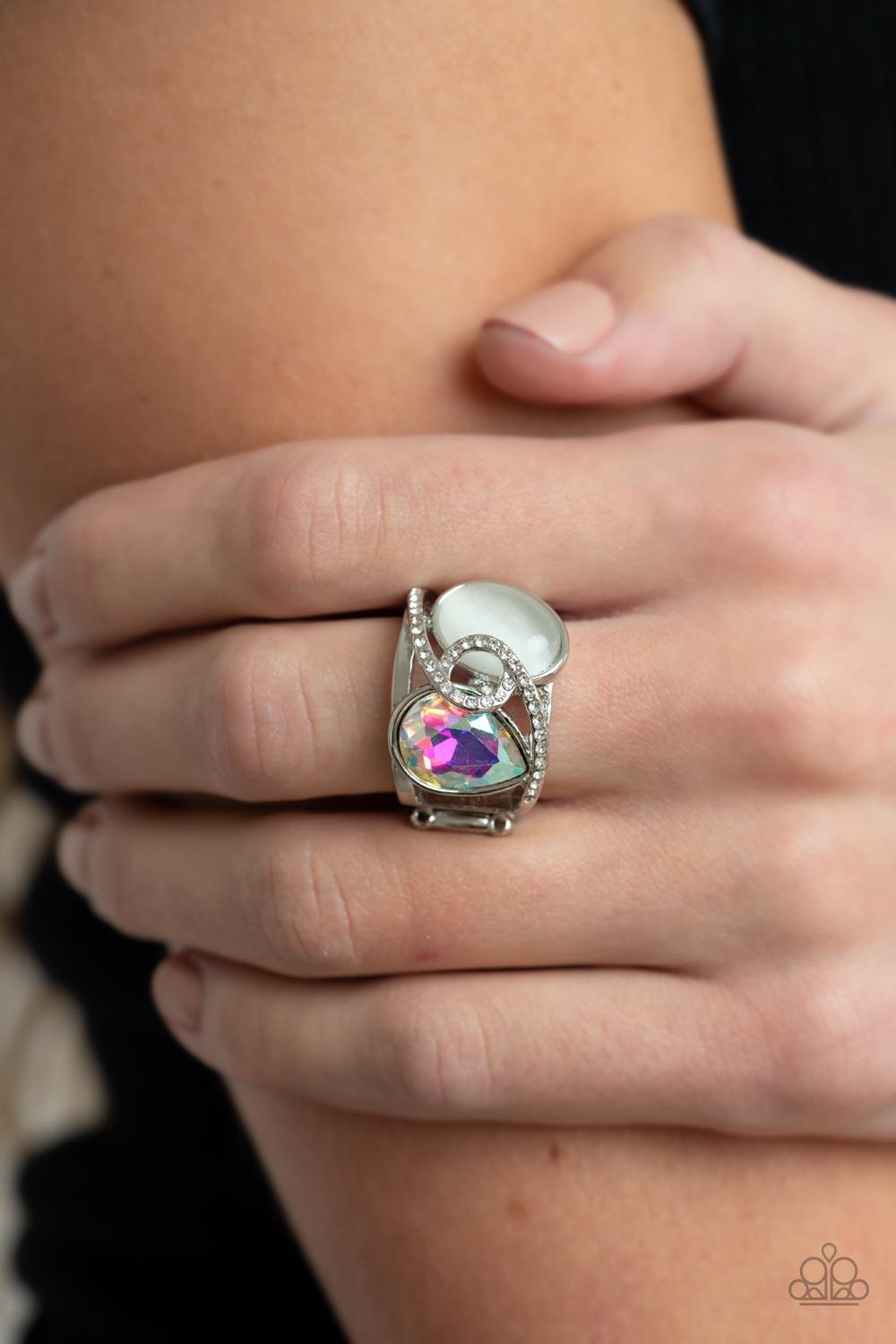 Paparazzi Accessories SELFIE-Indulgence - Multi A white rhinestone dotted silver ribbon loops and slants over a tilted white cat's eye stone and iridescent teardrop gem, culminating into a stellar centerpiece. Features a stretchy band for a flexible fit.