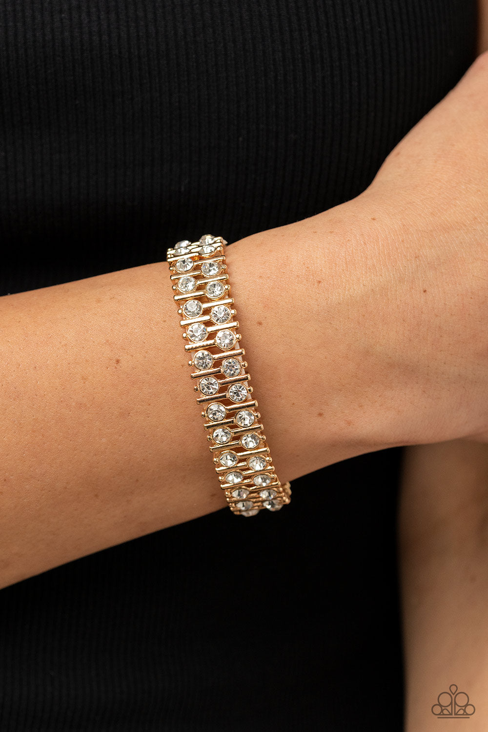 Paparazzi Accessories Generational Glimmer - Gold Attached to gold bars, a staggered display of solitaire white rhinestones alternates along a stretchy band around the wrist for an unexpected pop of shimmer around the wrist. Sold as one individual bracele