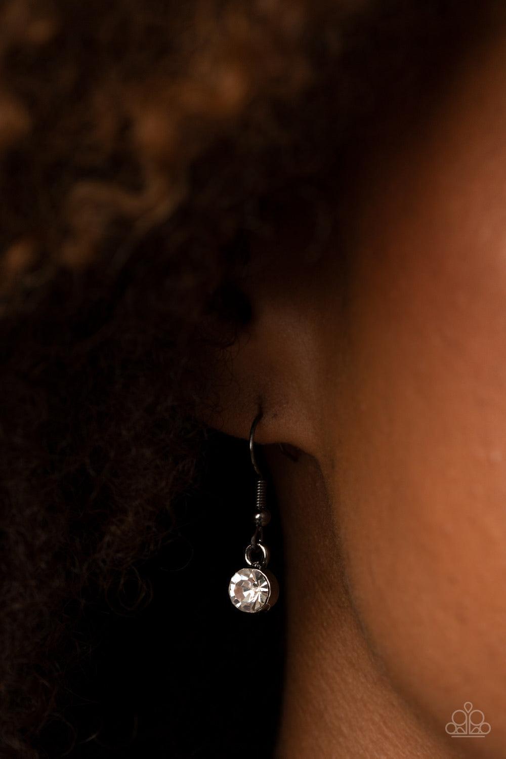 Paparazzi Accessories Unrivaled Sparkle - Black Tiers of white rhinestone encrusted frames delicately link below the collar, giving way to an oversized white teardrop rhinestone pendant for a timeless finish. Features an adjustable clasp closure. Sold as