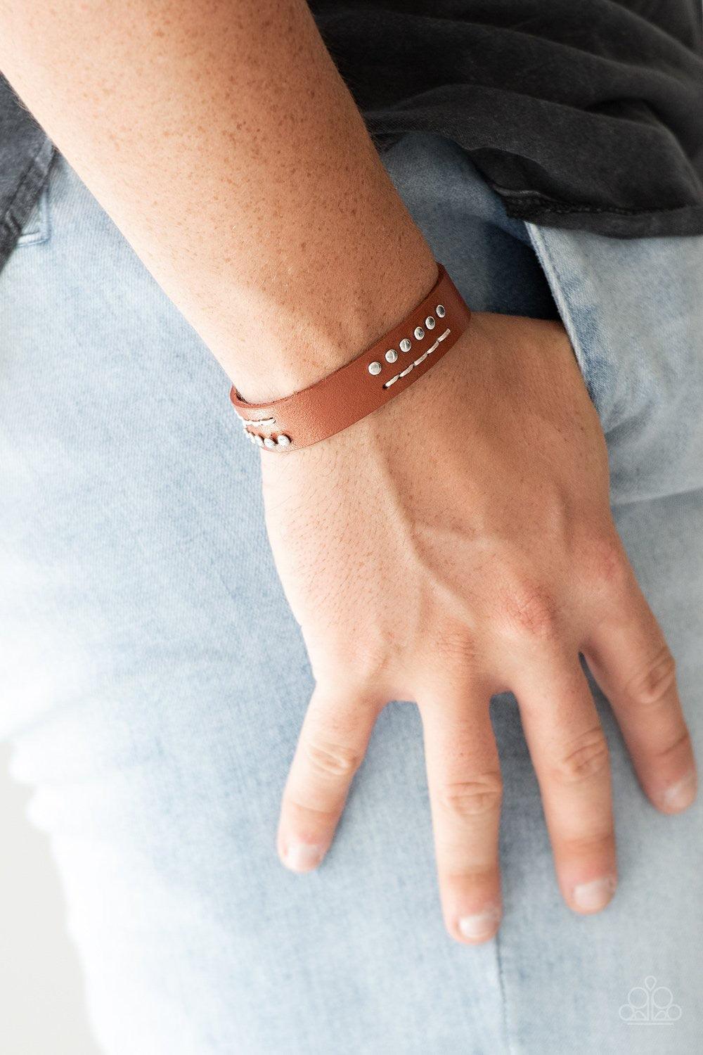 Paparazzi Accessories Always An Adventure - Brown Sections of shimmery silver studs and stitched white thread adorns the front of a brown leather band for an adventurous look. Features an adjustable snap closure. Jewelry