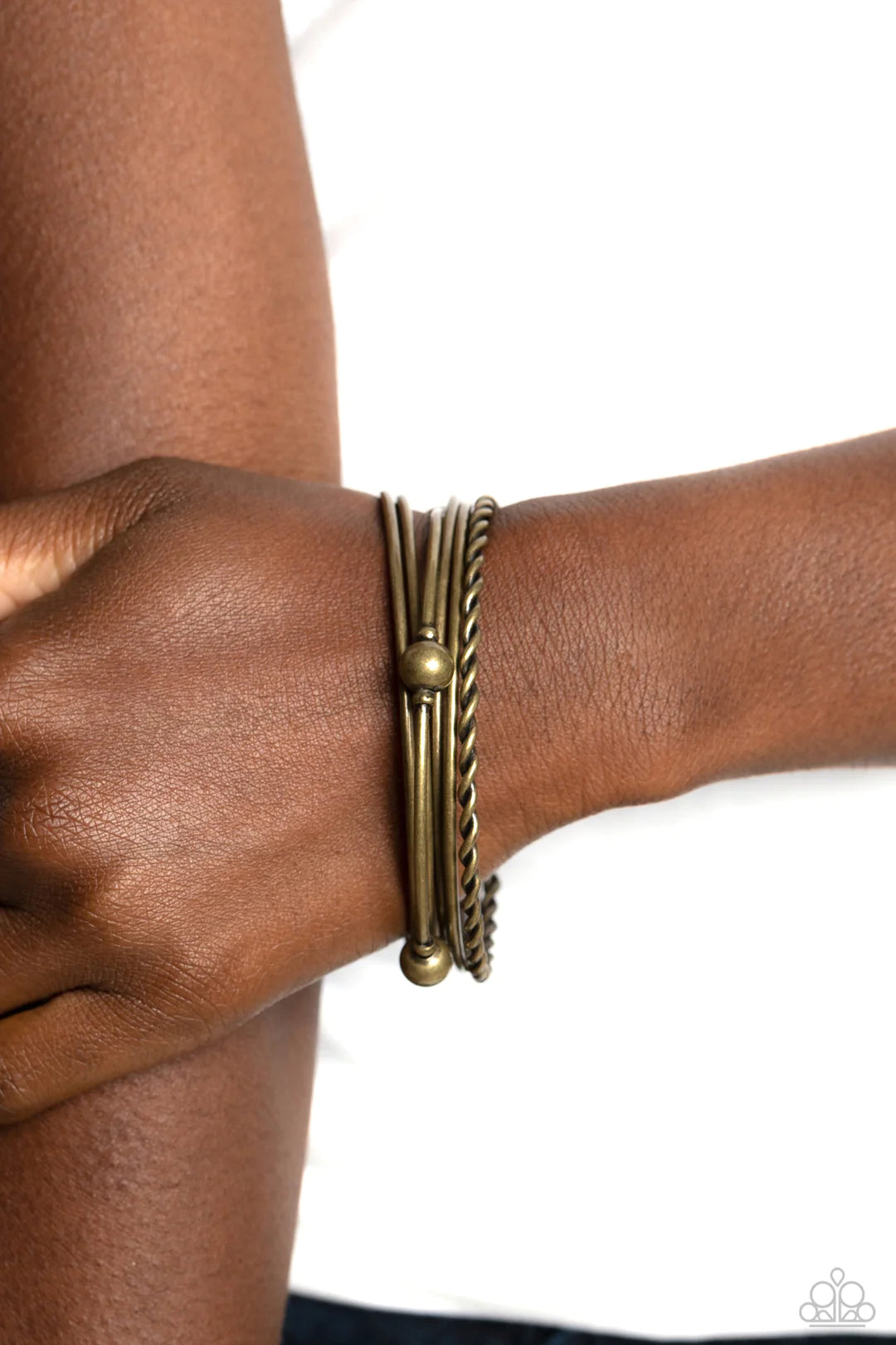 Paparazzi Accessories Lost and Found - Brass A collision of gritty brass bangles slides up and down the wrist for an industrially-layered look. One thin bangle features a braided texture, while another bangle features static brass accents and spheres for