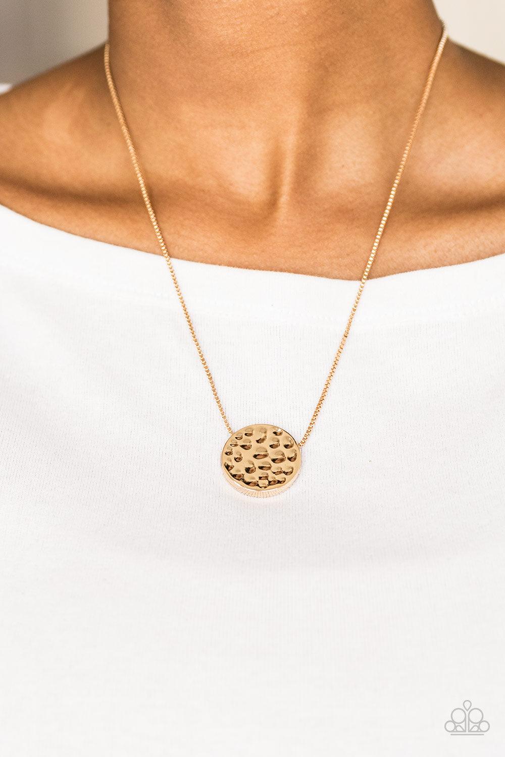 Paparazzi Accessories The BOLD Standard - Gold Delicately hammered in shimmery detail, a glistening gold pendant slides along a dainty gold box-chain below the collar for a bold look. Features an adjustable clasp closure. Sold as one individual necklace.