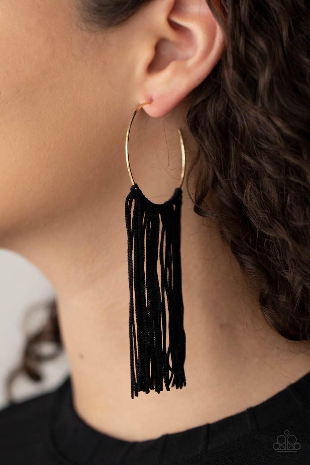 Paparazzi Accessories Flauntable Fringe - Gold A curtain of black cords stream from the center of a dainty gold hoop, creating a glamorous fringe. Earring attaches to a standard post fitting. Hoop measures approximately 1 3/4" in diameter. Sold as one pai