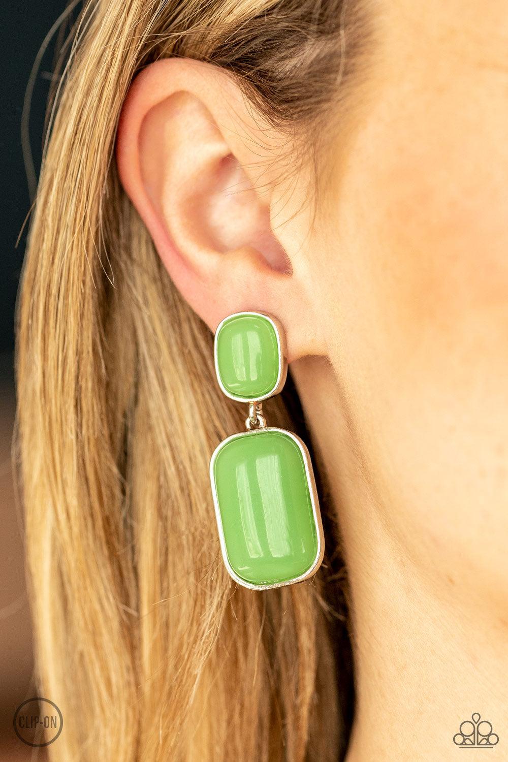 Paparazzi Accessories Meet Me At The Plaza - Green Encased in sleek silver frames, milky Green Ash beads link into an oversized lure for a whimsically refined flair. Earring attaches to a standard clip-on fitting. Sold as one pair of clip-on earrings. Ear