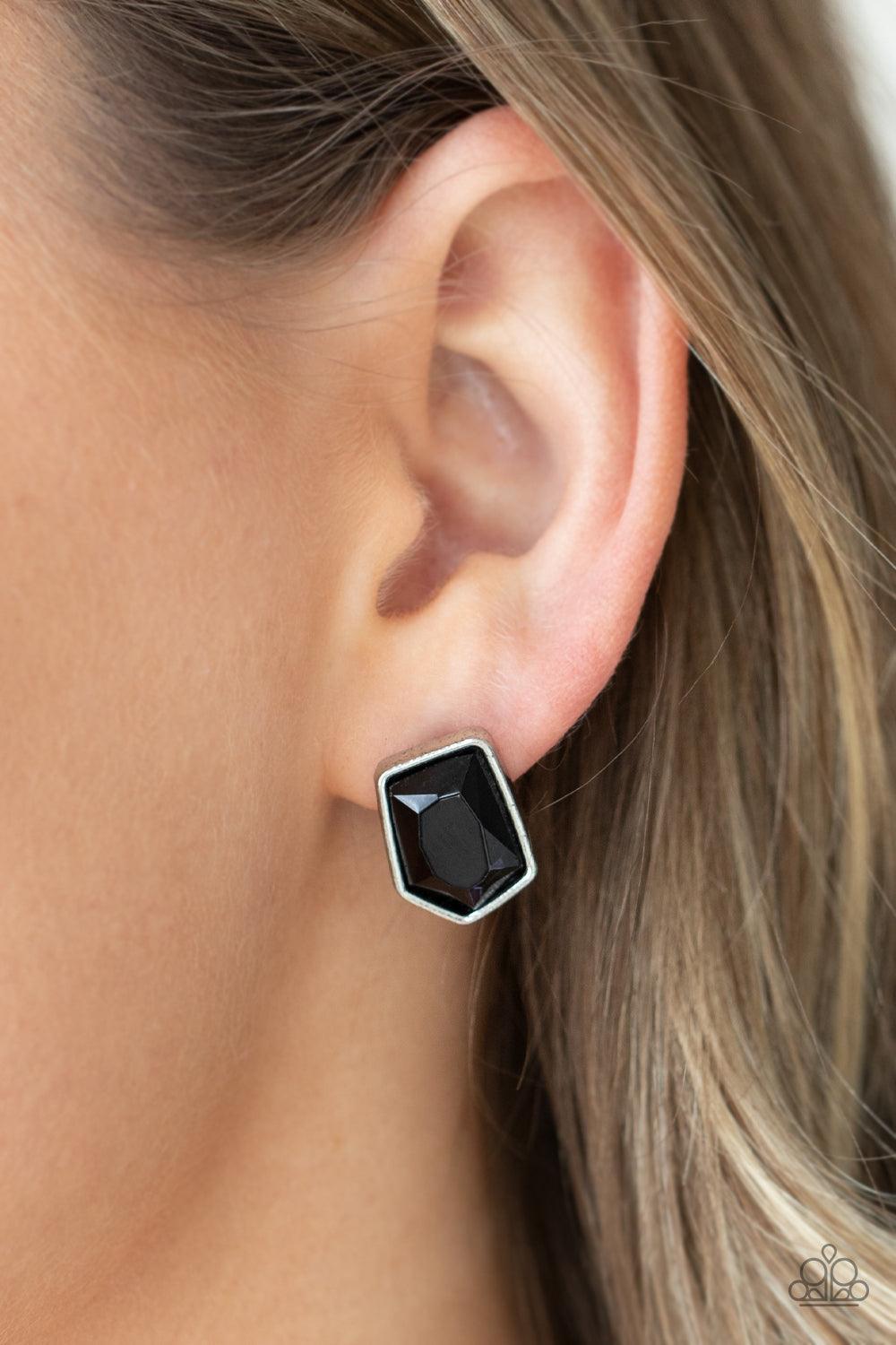 Paparazzi Accessories Indulge Me - Black Featuring a raw asymmetrical cut, a glittery black gem is encased inside a sleek silver frame, creating an edgy display. Earring attaches to a standard post fitting. Sold as one pair of post earrings. Jewelry