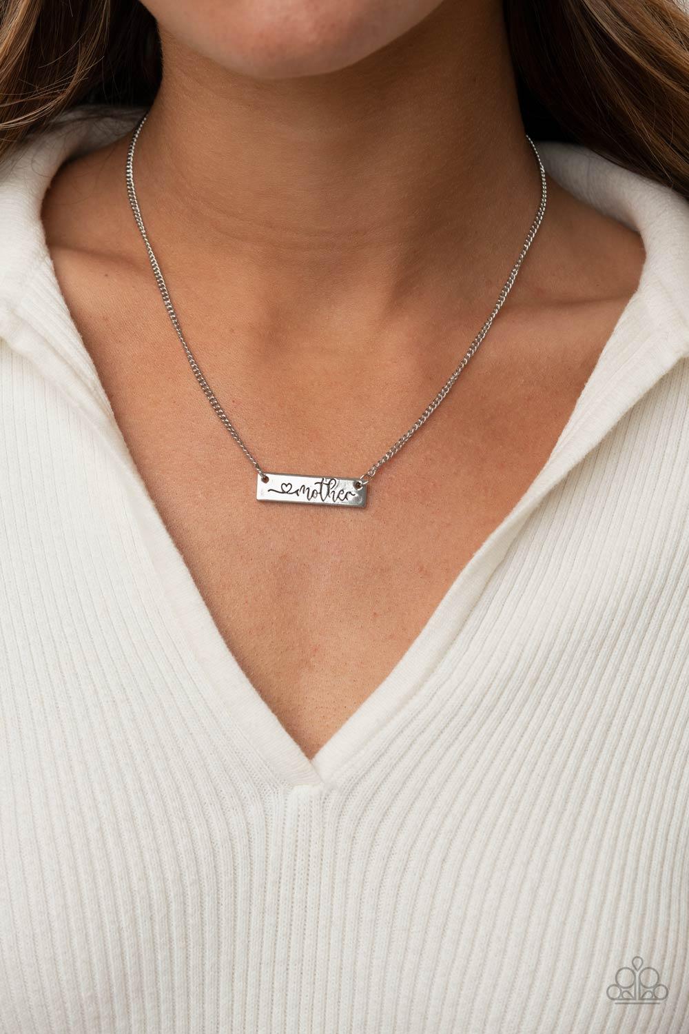 Paparazzi Accessories Joy Of Motherhood - Silver Stamped in a heart and the word, "Mother," a glistening silver plate is suspended by a classic silver chain below the collar, creating a whimsy sentimental pendant. Features an adjustable clasp closure. Sol