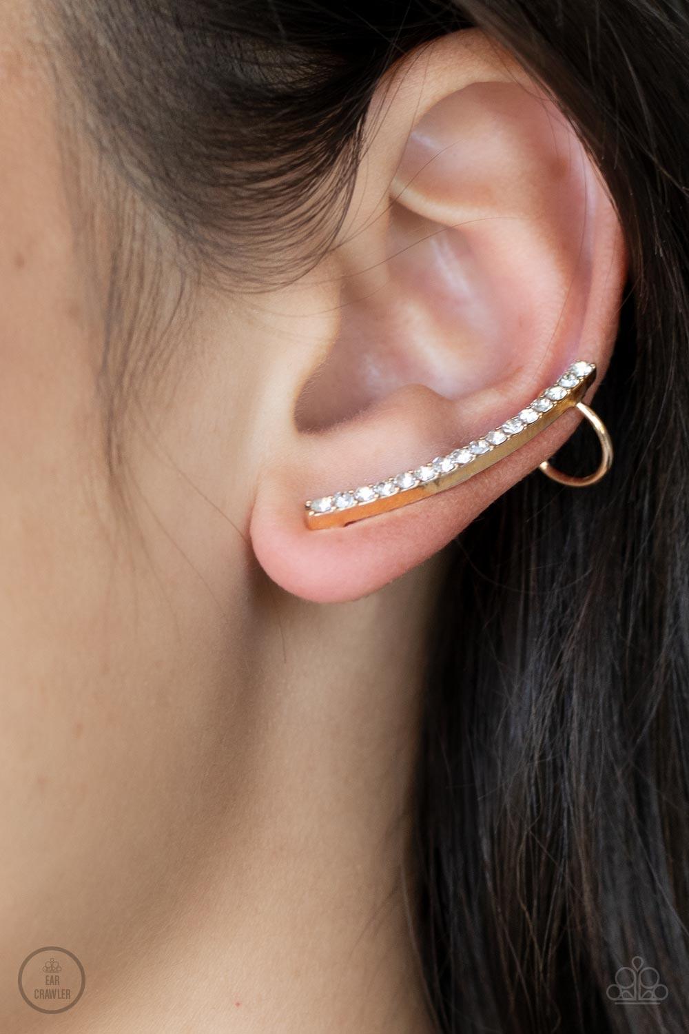 Paparazzi Accessories Sleekly Shimmering - Gold Featuring pronged gold fittings, a dainty row of stacked white rhinestones gently curves as it climbs the ear for a flawless fashion. Features a dainty cuff attached to the top for a secure fit. Sold as one