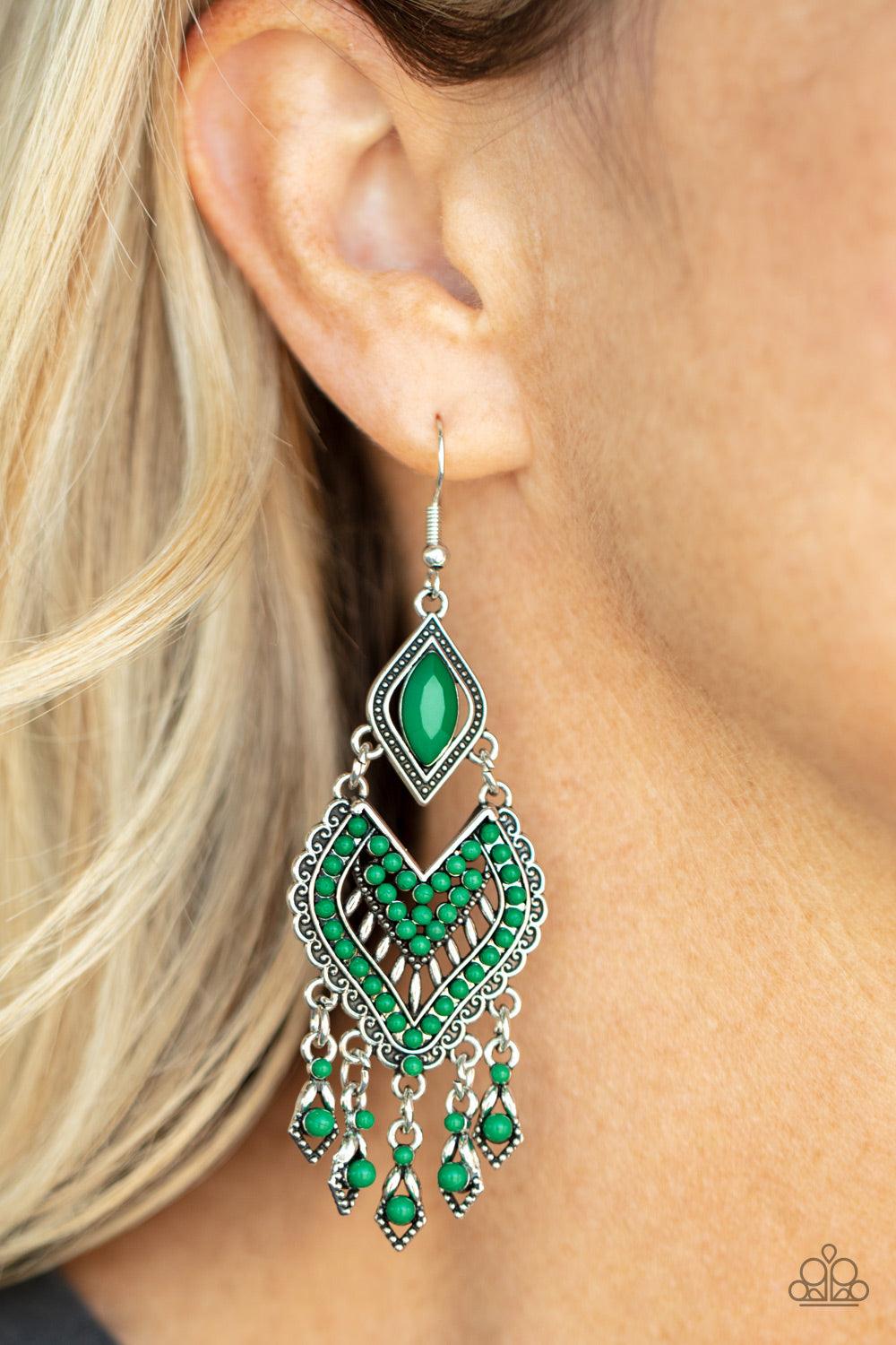 Paparazzi Accessories Dearly Debonair - Green Featuring the refreshing green hue of Leprechaun, dainty seed beads adorn the front of a scalloped heart shaped frame that swings from the bottom of a studded silver frame adorned in a marquise cut Leprechaun