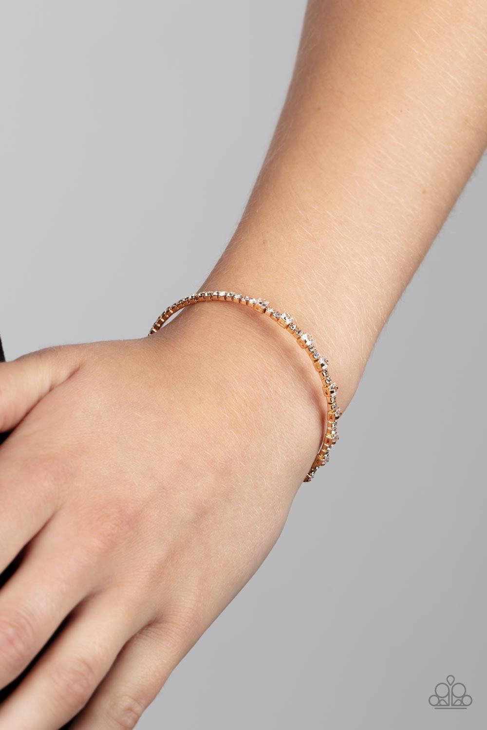 Paparazzi Accessories Timelessly Tiny - Gold Featuring sleek gold fittings, a classic band of dainty white rhinestones is interrupted with square cut white rhinestones, adding a timeless twist to the stackable cuff. Sold as one individual bracelet. Bracel