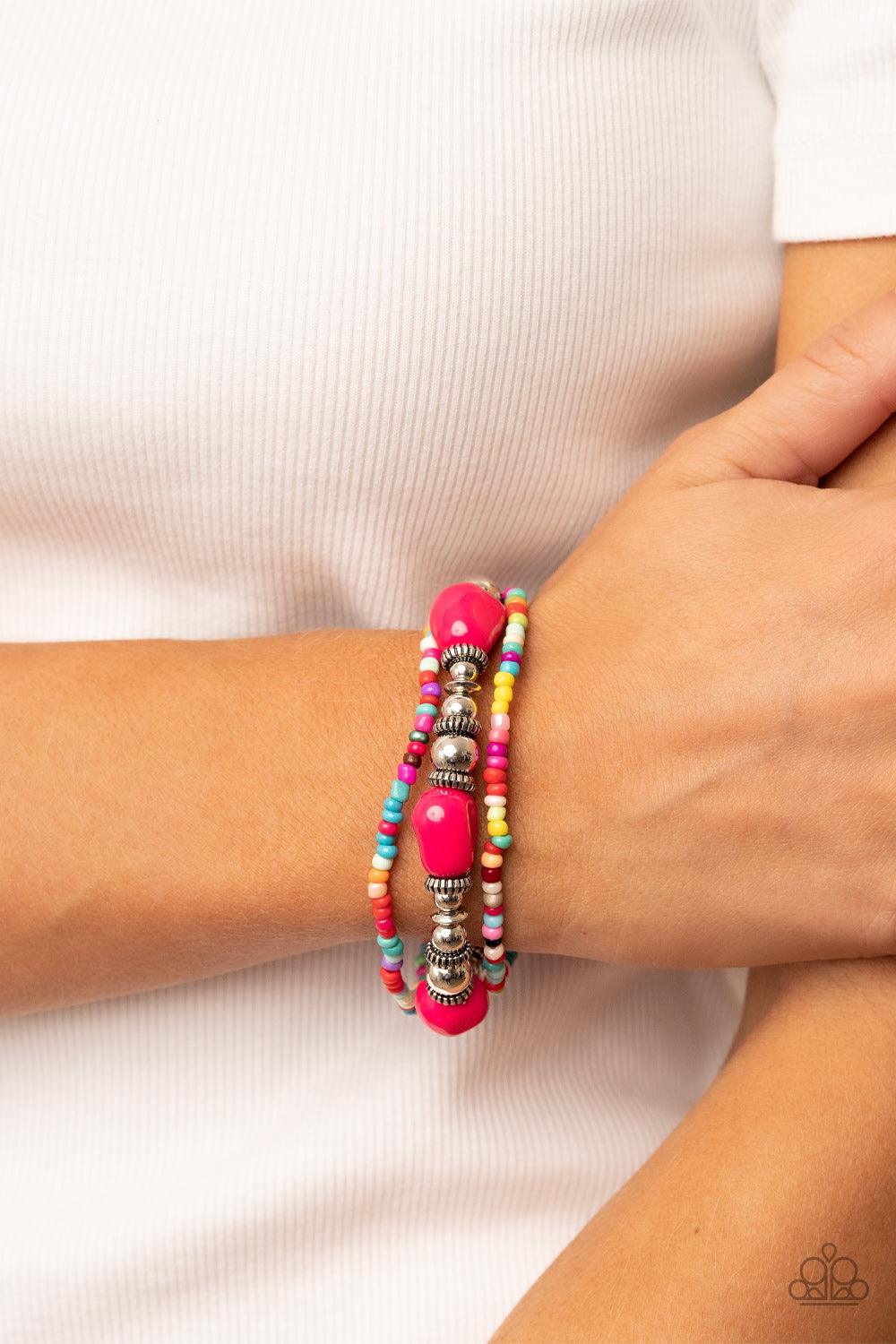 Paparazzi Accessories Confidently Crafty - Pink A pair of multicolored seed beaded stretchy bracelets joins a stretchy strand of shiny silver beads, textured silver accents, and faceted pink beads around the wrist, creating colorful layers. Sold as one se