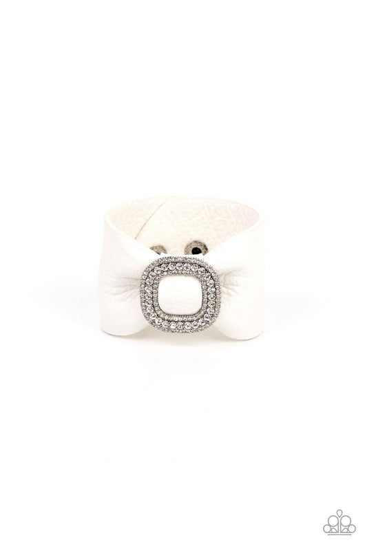 Paparazzi Accessories Lights, SELFIE, Action! - White A thick white pleather band delicately knots around the wrist. Stacked with brilliant white rhinestones, a dramatic silver buckle sparkles at the center of the wrist for a dramatic finish. Features an