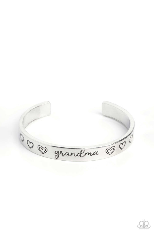 Paparazzi Accessories A Grandmothers Love - Silver Brushed in a polished sheen, a skinny silver bar curls around the wrist, creating a rustic cuff. Featuring a heart motif, the skinny cuff is engraved with the word “grandma” with various styles of hearts
