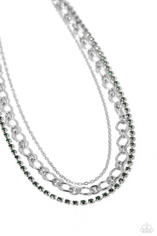 Paparazzi Accessories Tasteful Tiers - Green A dainty strand of emerald green rhinestones, set in silver square fittings, joins a dainty silver strand of silver chain and a silver oval link chain below the collar, creating refined layers. Features an adju