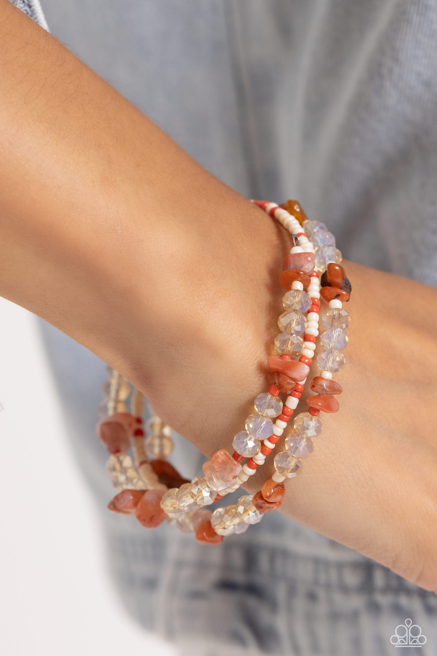 Paparazzi Accessories Notoriously Nuanced - Orange Threaded along a coiled wire, a fashionable collection of Tender Peach, ivory, and Burnt Sienna seed beads and glassy champagne beads combine with chiseled Burnt Sienna natural stones as they coalesce aro