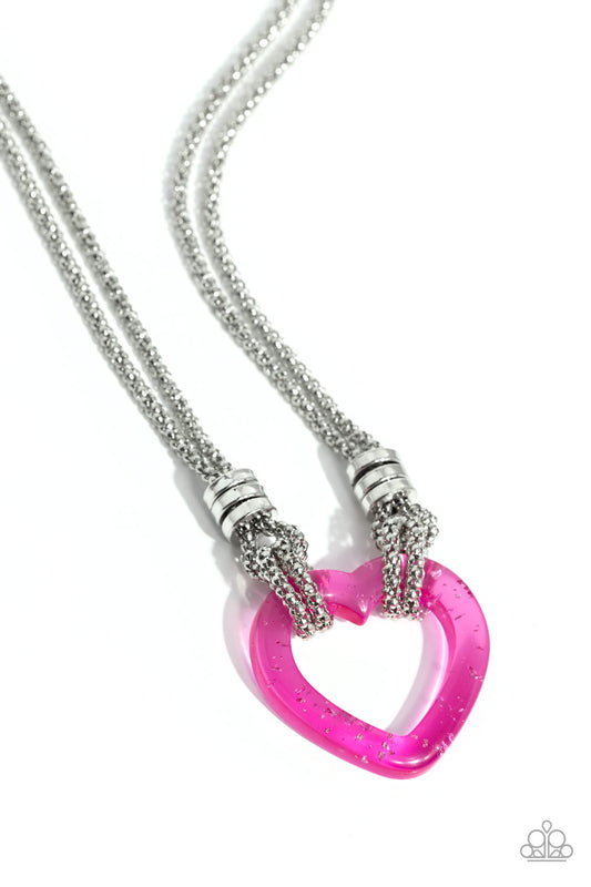 Paparazzi Accessories Lead with Your Heart - Pink Featuring a double-layered display of silver popcorn chain, a silver-flecked pink acrylic heart frame cascades down the neckline. Infused atop the acrylic heart, a trio of high-sheen silver rings adorns th