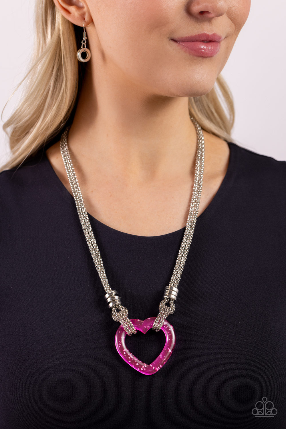 Paparazzi Accessories Lead with Your Heart - Pink Featuring a double-layered display of silver popcorn chain, a silver-flecked pink acrylic heart frame cascades down the neckline. Infused atop the acrylic heart, a trio of high-sheen silver rings adorns th