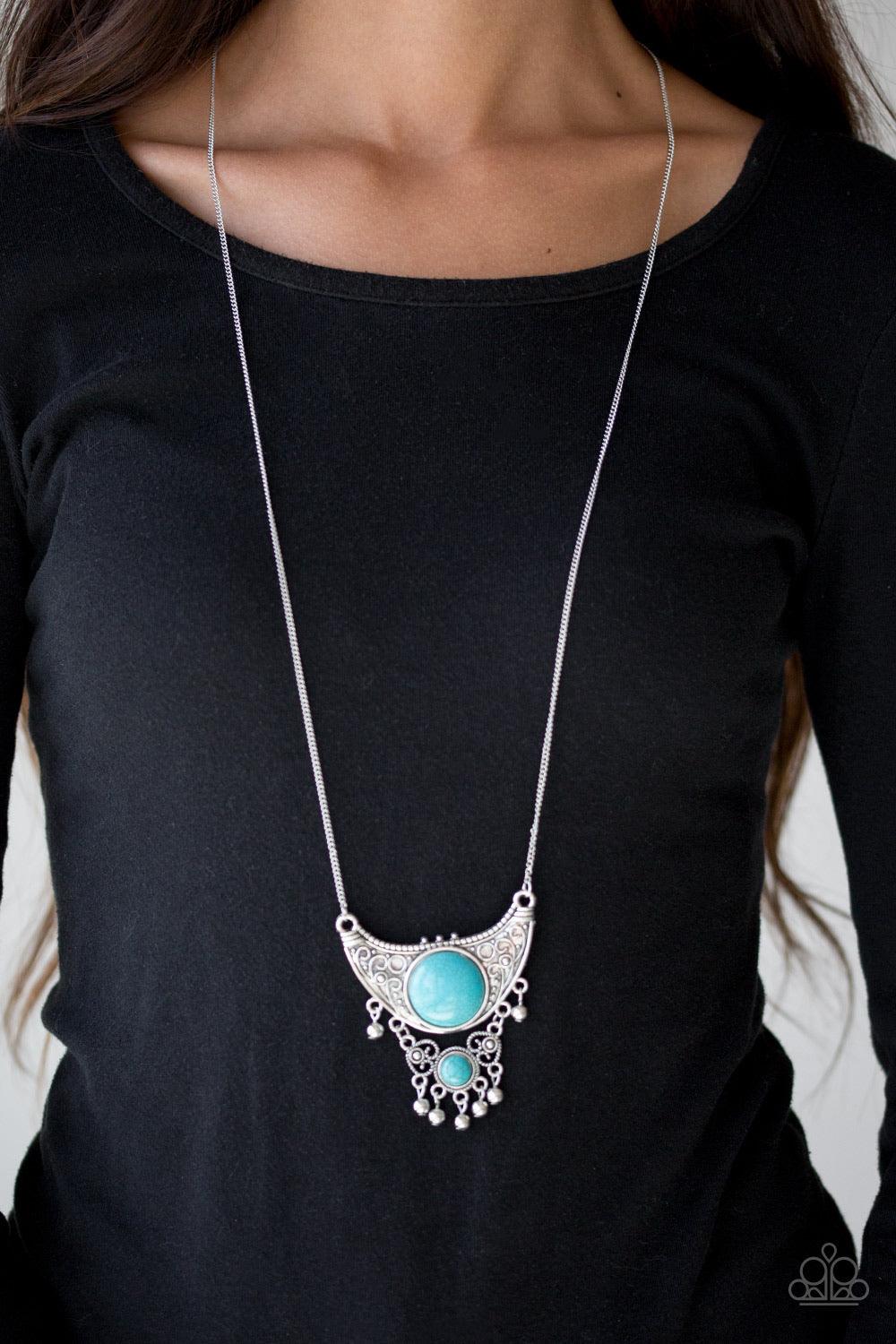 Paparazzi Accessories Summit Style - Blue Embossed in dotted and swirling details, a large silver crescent attaches to a smaller frilly frame, creating a stacked pendant. Swinging from the bottom of a lengthened silver chain, the tribal inspired pendant f