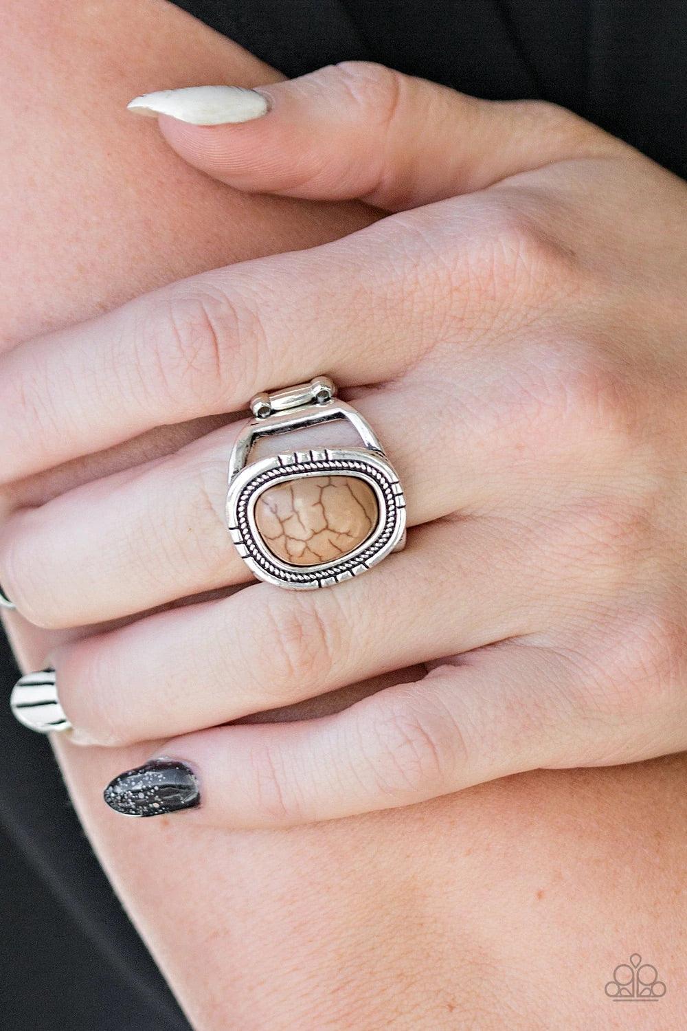 Paparazzi Accessories Out On The Range - Brown An earthy brown stone is pressed into an asymmetrical silver frame radiating with tactile textures for a seasonal look. Features a stretchy band for a flexible fit. Sold as one individual ring. Jewelry