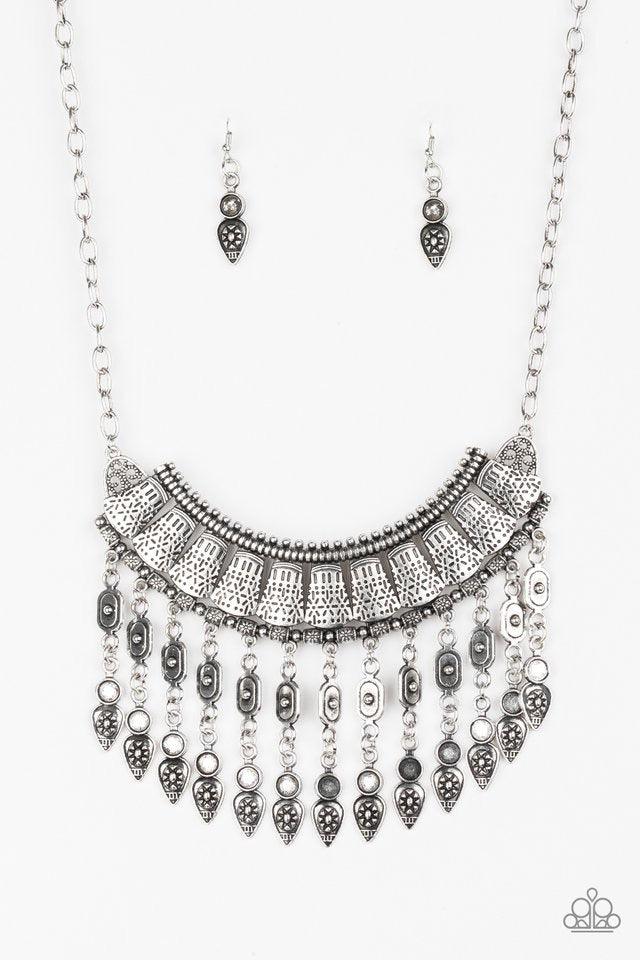 Paparazzi Accessories The Desert is Calling - Silver Stenciled in tribal inspired details, shimmery silver plates connect below the collar, coalescing into a crescent pendant. Embossed and studded in ornate patterns, antiqued silver beads swing from the b