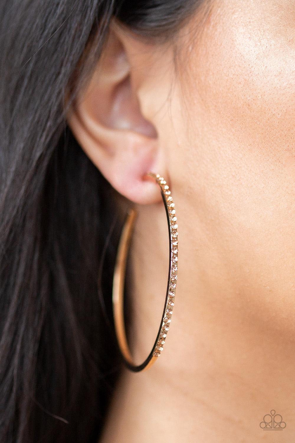 Paparazzi Accessories Trending Twinkle - Gold The front half of a gold hoop is encrusted in peach rhinestones for a radiant look. Earring attaches to a standard post fitting. Hoop measures 2 1/4" in diameter. Jewelry