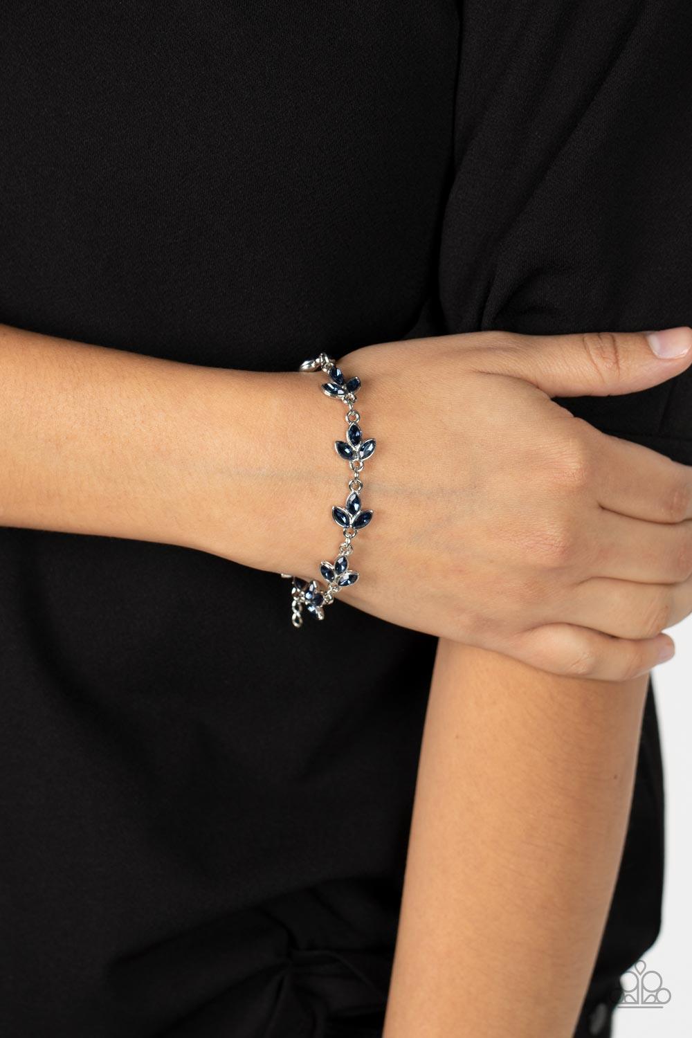 Paparazzi Accessories Gala Garlands - Blue Twinkling trios of marquise cut blue rhinestones gather into leafy frames as they delicately link around the wrist, resulting in a radiant centerpiece. Features an adjustable clasp closure. Sold as one individual