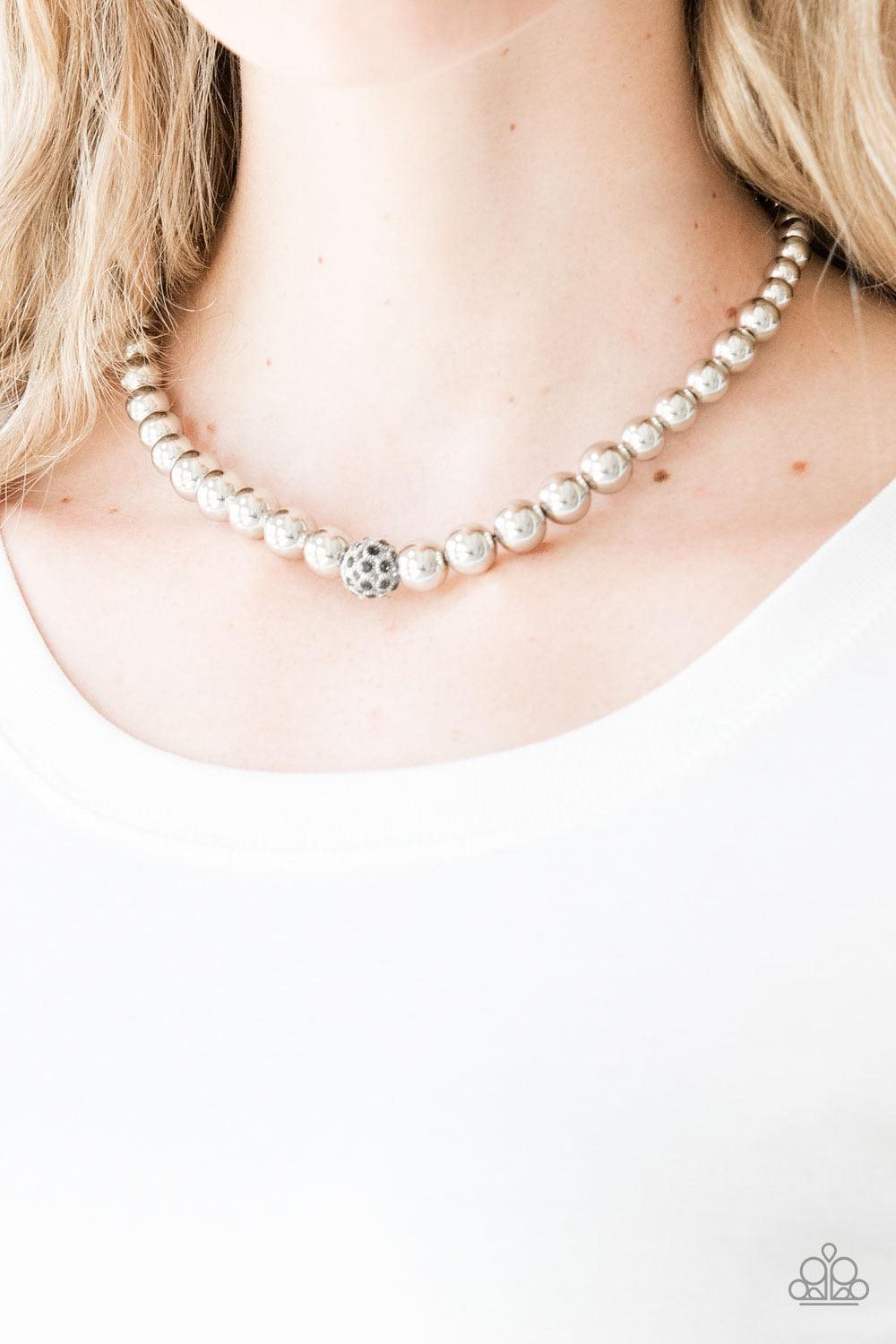 Paparazzi Accessories High-Stakes Fame - Silver Gradually increasing in size near the center, glistening silver beads are threaded along an invisible wire below the collar. Encrusted in smoky rhinestones, a sparkling silver bead adorns the center for a re