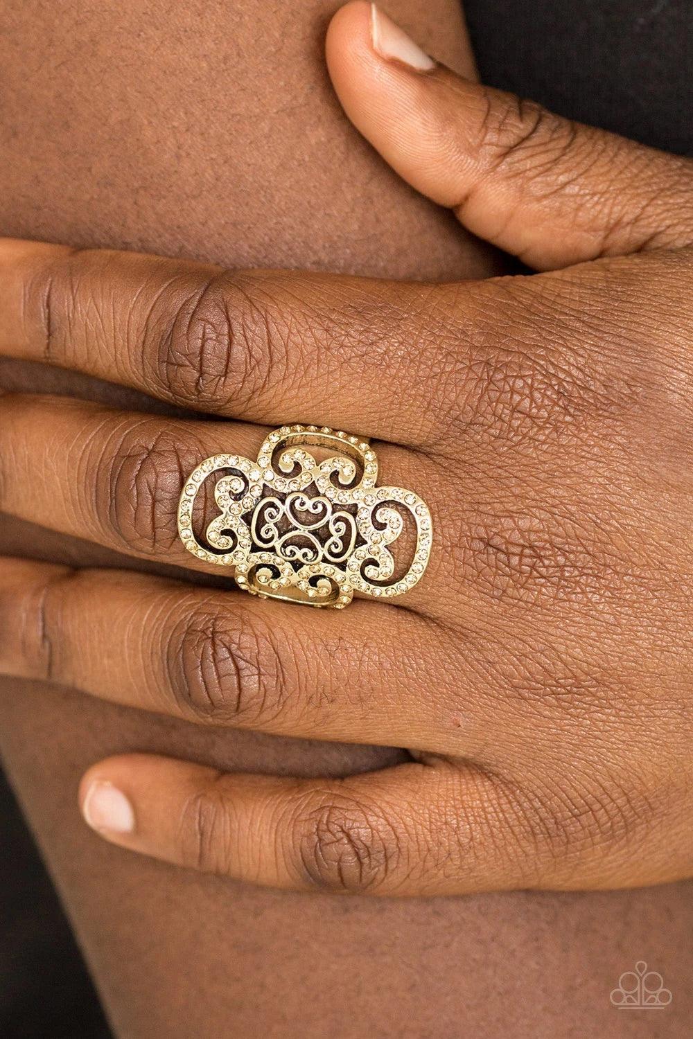 Paparazzi Accessories Regal Regalia - Brass Dainty topaz rhinestones are encrusted along a glistening brass frame radiating with regal filigree for a refined look. Features a stretchy band for a flexible fit. Sold as one individual ring. Jewelry