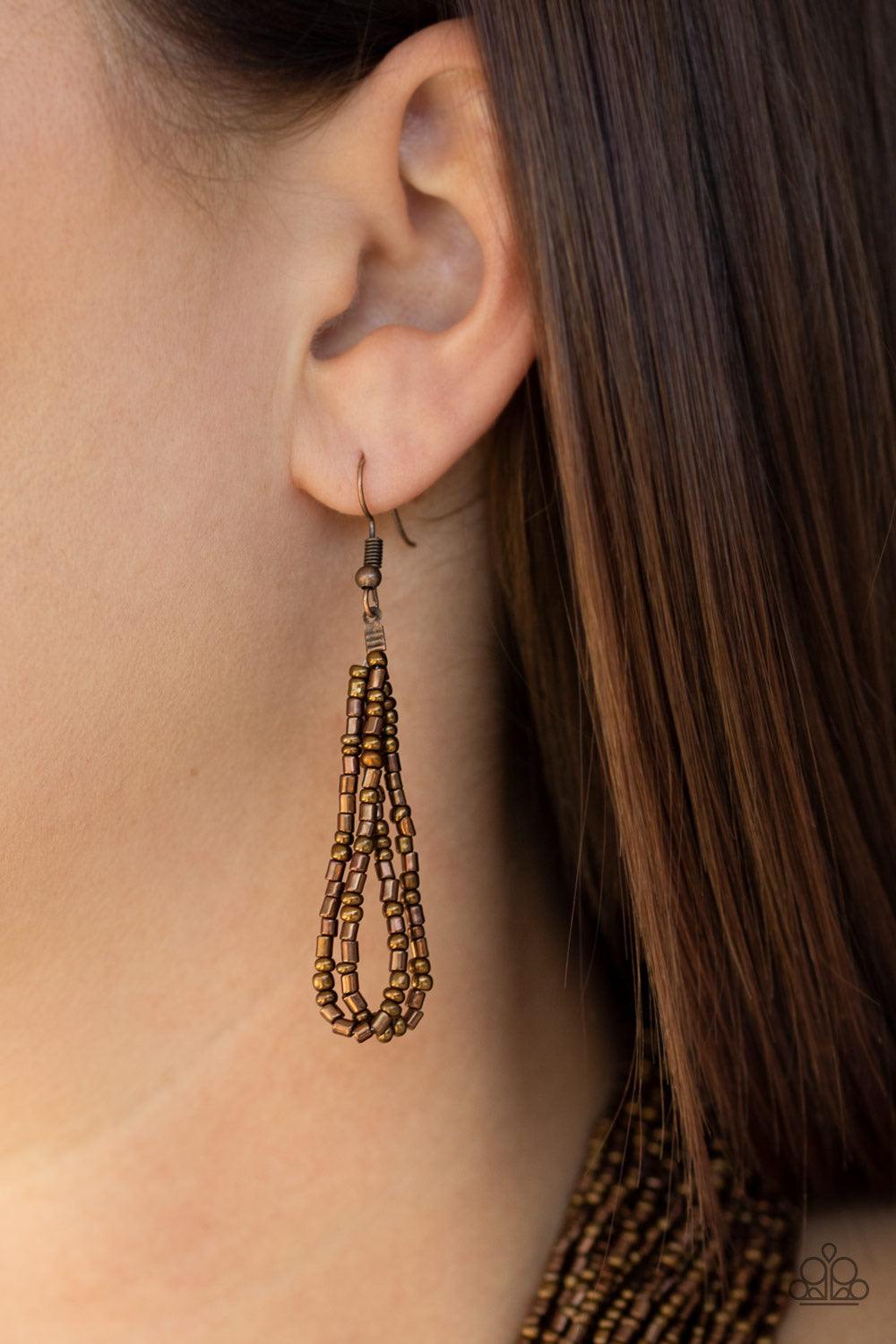 Paparazzi Accessories Dauntless Dazzle - Copper Brushed in an icy metallic shimmer, countless strands of copper seed beads drape across the chest in a bold fashion. Featuring a collision of shapes and shimmer, the glittery strands connect to two large cop