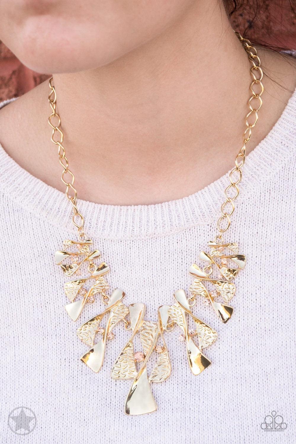 Paparazzi Accessories The Sands Of Time - Gold Twisted gold hourglasses dance along a chunky gold chain with tiny peach rhinestones adding sparkling, elegant accents. Beautiful textured pieces add depth to the design. Features an adjustable clasp closure.