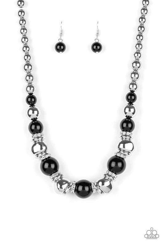 Paparazzi Accessories Hollywood HAUTE Spot - Black A collection of oversized shiny black, silver rings, and asymmetrical silver beads are threaded along an invisible wire below the collar. White rhinestone encrusted rings are sprinkled between the refined