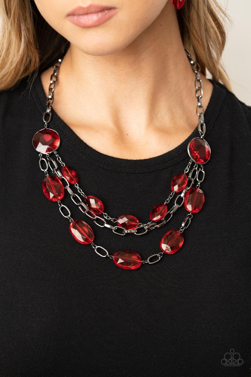 Paparazzi Accessories I Need A GLOW-cation - Red Strung between two matching red gem-like fittings, two glittery rows of red oval gems flank a strand of bold gunmetal chain below the collar for a flawlessly layered look. Features an adjustable clasp closu
