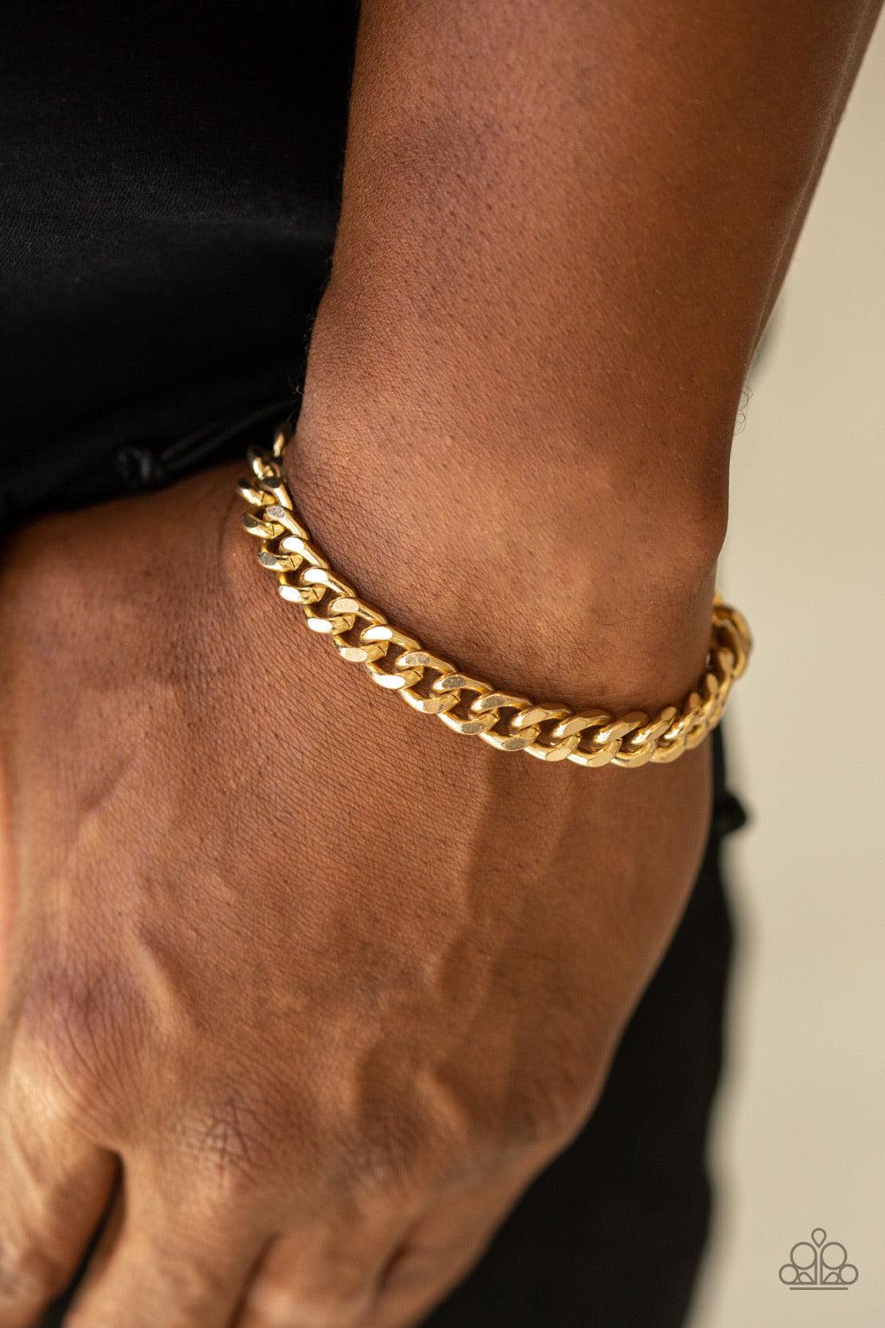 Paparazzi Accessories Rulebreaker - Gold Shiny black cording knots around the ends of an ornate gold beveled cable chain that is wrapped across the top of the wrist for a versatile look. Features an adjustable sliding knot closure. Jewelry