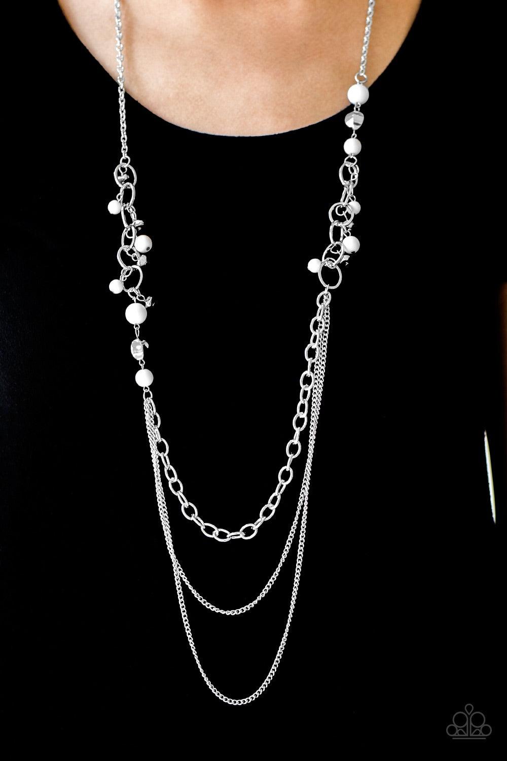 Paparazzi Accessories Carefree And Capricious - White Polished white and faceted silver beads trickle along shimmery silver hoops for an asymmetrical look. The colorful beading gives way to layers of shimmery silver chain for a seasonal finish. Features a