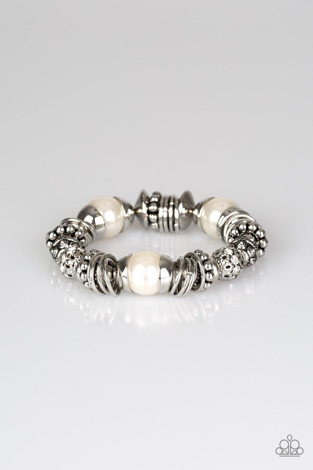 Paparazzi Accessories Uptown Tease - White A collection of oversized white pearls, mismatched silver accents, and white rhinestone encrusted beads are threaded along a stretchy band around the wrist for a show-stopping look. Jewelry