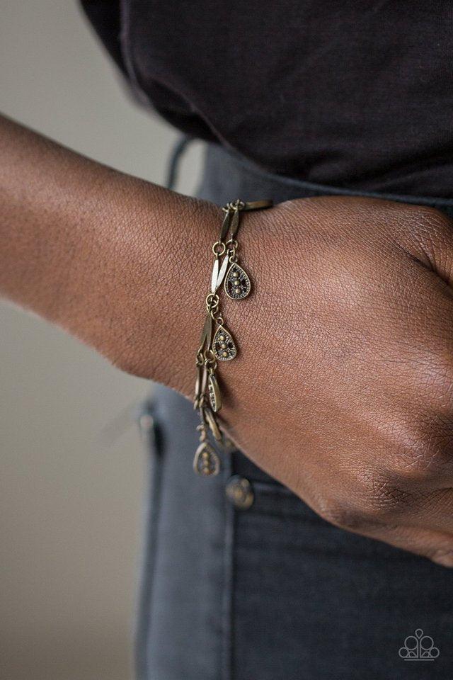 Paparazzi Accessories Gypsy Glee - Brass Glistening brass rods and ornate teardrops link around the wrist in two rows, creating a playful fringe. Features an adjustable clasp closure. Jewelry
