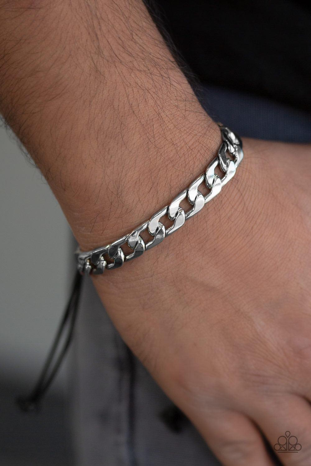 Paparazzi Accessories Score! - Silver Shiny black cording knots around the ends of a thick shiny silver curb chain that is wrapped across the top of the wrist for a versatile look. Features an adjustable sliding knot closure. Jewelry
