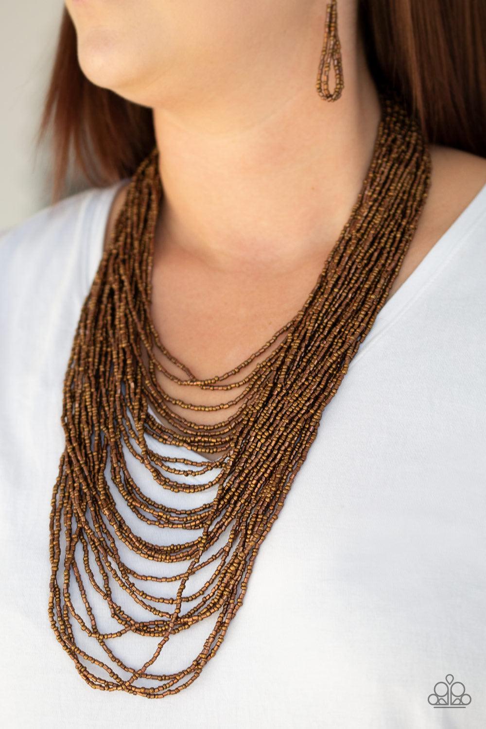 Paparazzi Accessories Dauntless Dazzle - Copper Brushed in an icy metallic shimmer, countless strands of copper seed beads drape across the chest in a bold fashion. Featuring a collision of shapes and shimmer, the glittery strands connect to two large cop